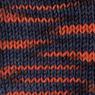 knit swatch of Hand dyed yarn in navy and rusty orange mixtape music colorway starman on wool yarn fingering, dk, worsted, and bulky
